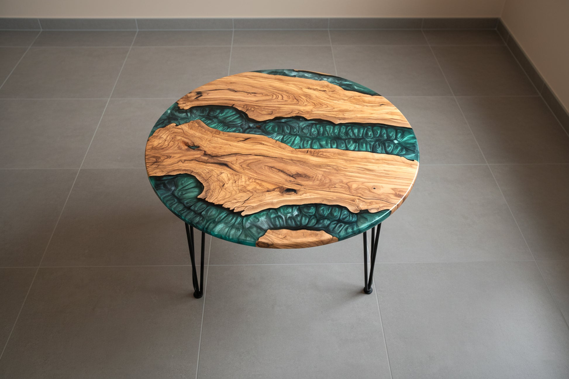 Mesa de centro de madera de olivo con resina epoxi verde sobre suelo rústico