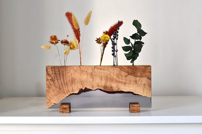 Portaplantas pequeño de madera natural con flores secas y diseño artesanal.