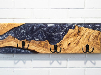 Perchero de pared en madera de olivo con resina epoxi violeta, fotografía de estudio
