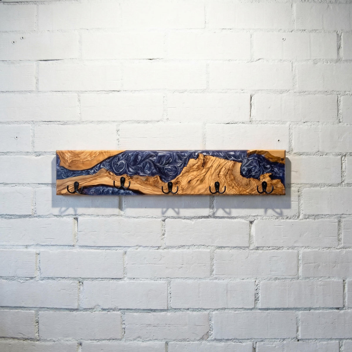 Vista completa de perchero de pared en madera de olivo con resina epoxi violeta