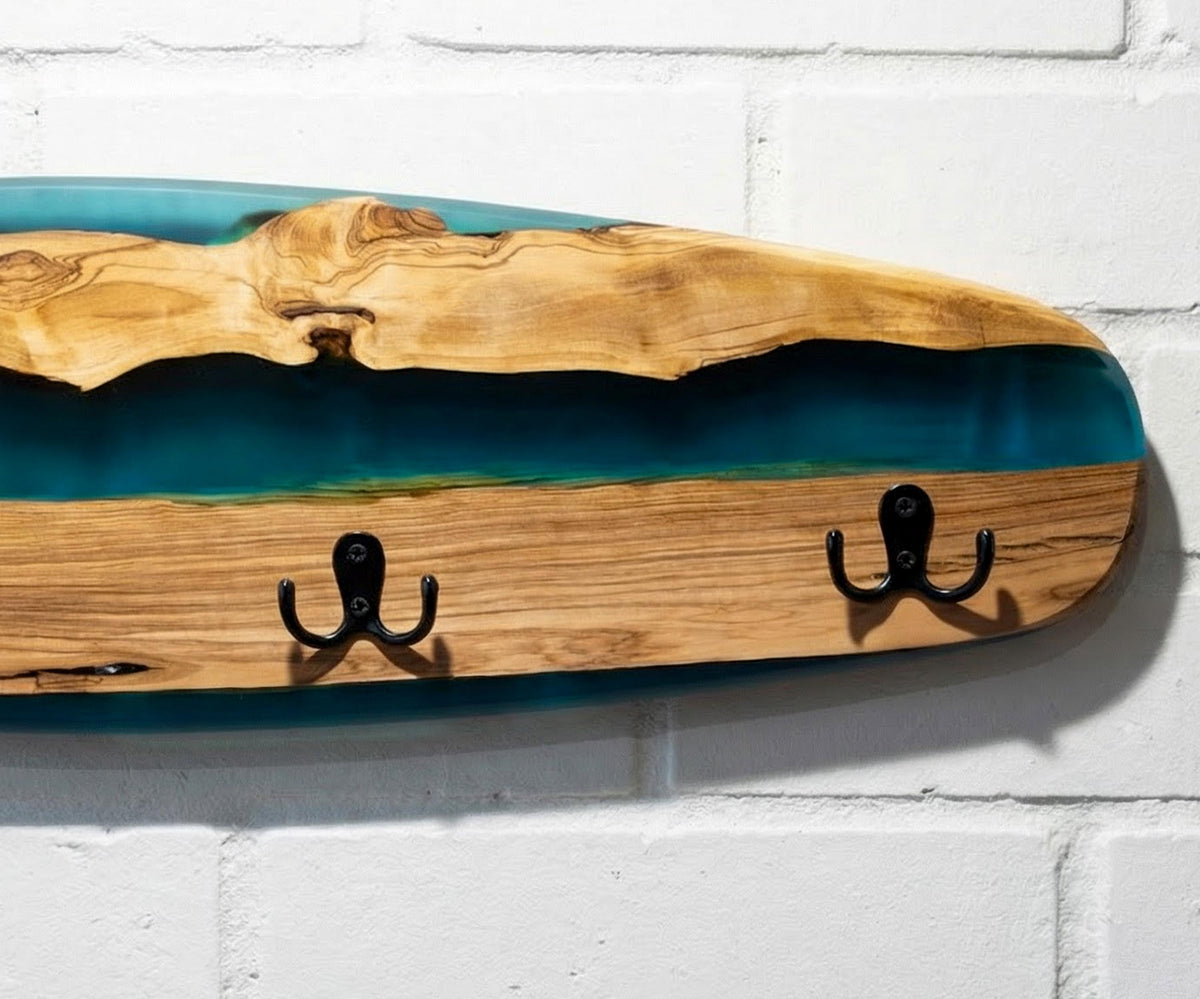 Perchero de madera de olivo con resina azul en forma de tabla de skate