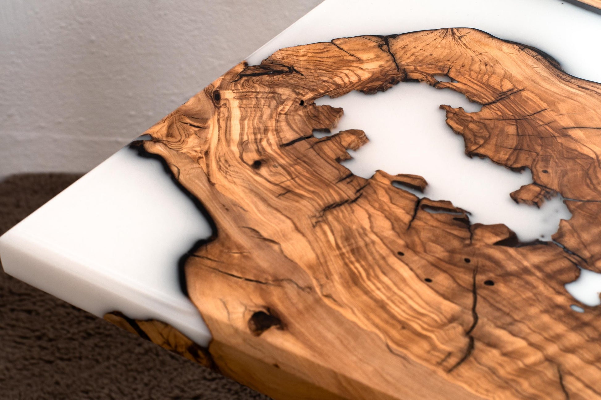 Primer plano de la veta de madera de olivo y la resina epoxi blanca