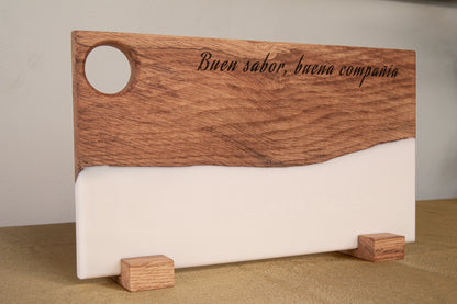 Tabla de madera de roble y resina epoxi blanca personalizada con frase grabada, apoyada en soportes de madera