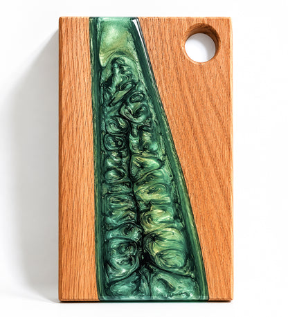 Tabla artesanal de charcutería de madera de roble y resina epoxi verde con diseño tipo río, fotografiada sobre fondo blanco de estudio con luz natural. Ideal como tabla de quesos, tabla de presentación, tabla para pan o regalo único para el hogar.