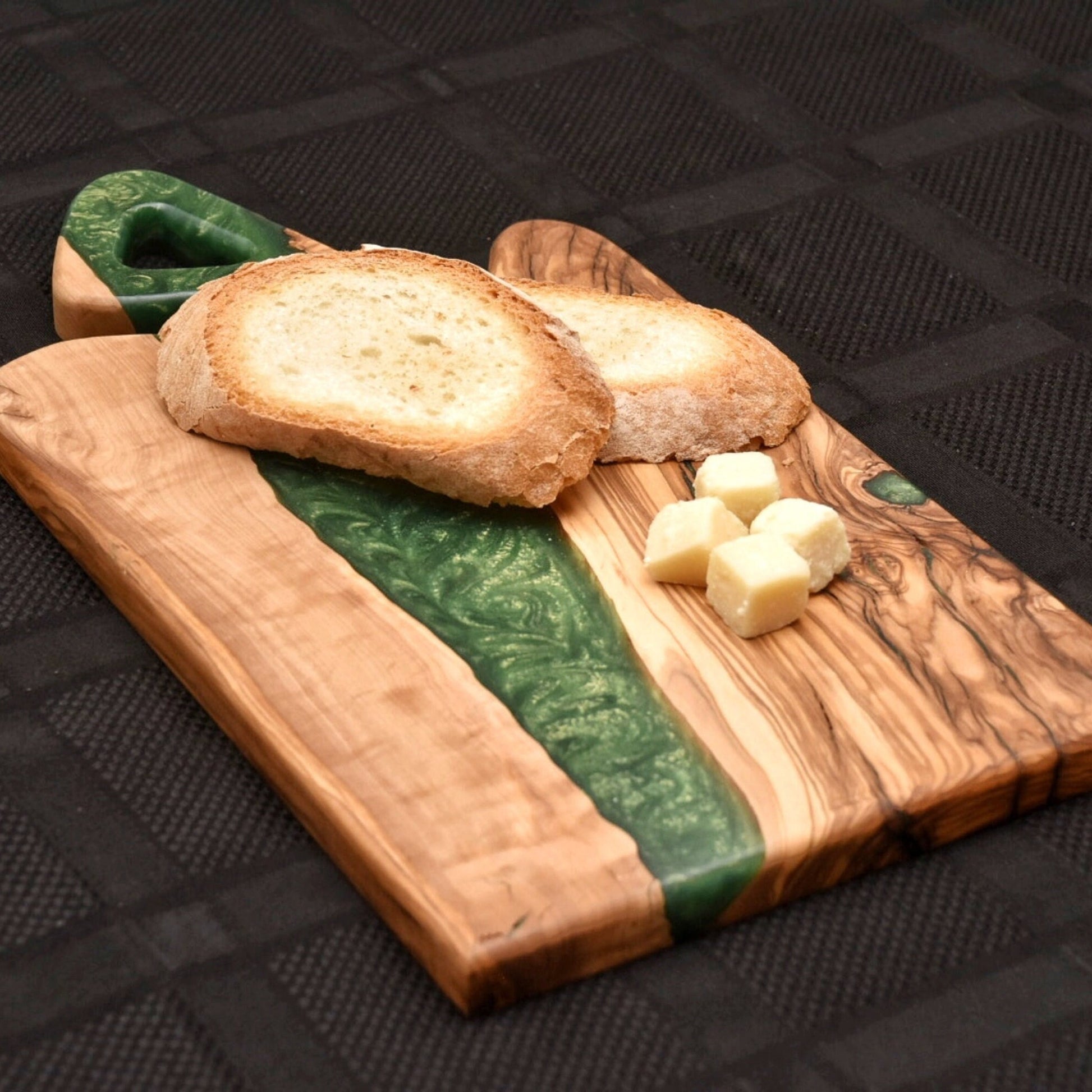 Tabla de madera y resina con pan y queso sobre superficie