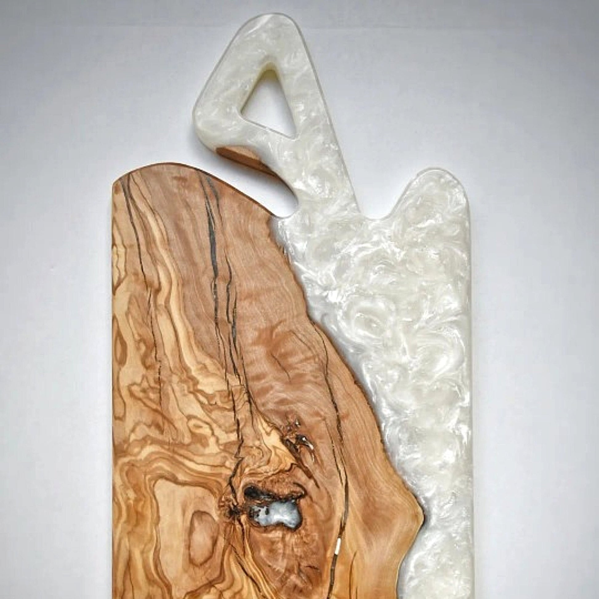 Detalle de tabla de olivo con río de resina epoxi blanca