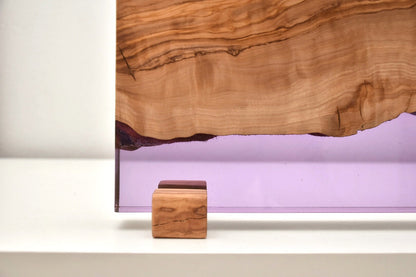 Detalle de portaplantas artesanal con resina epoxi lila y veta natural de olivo.