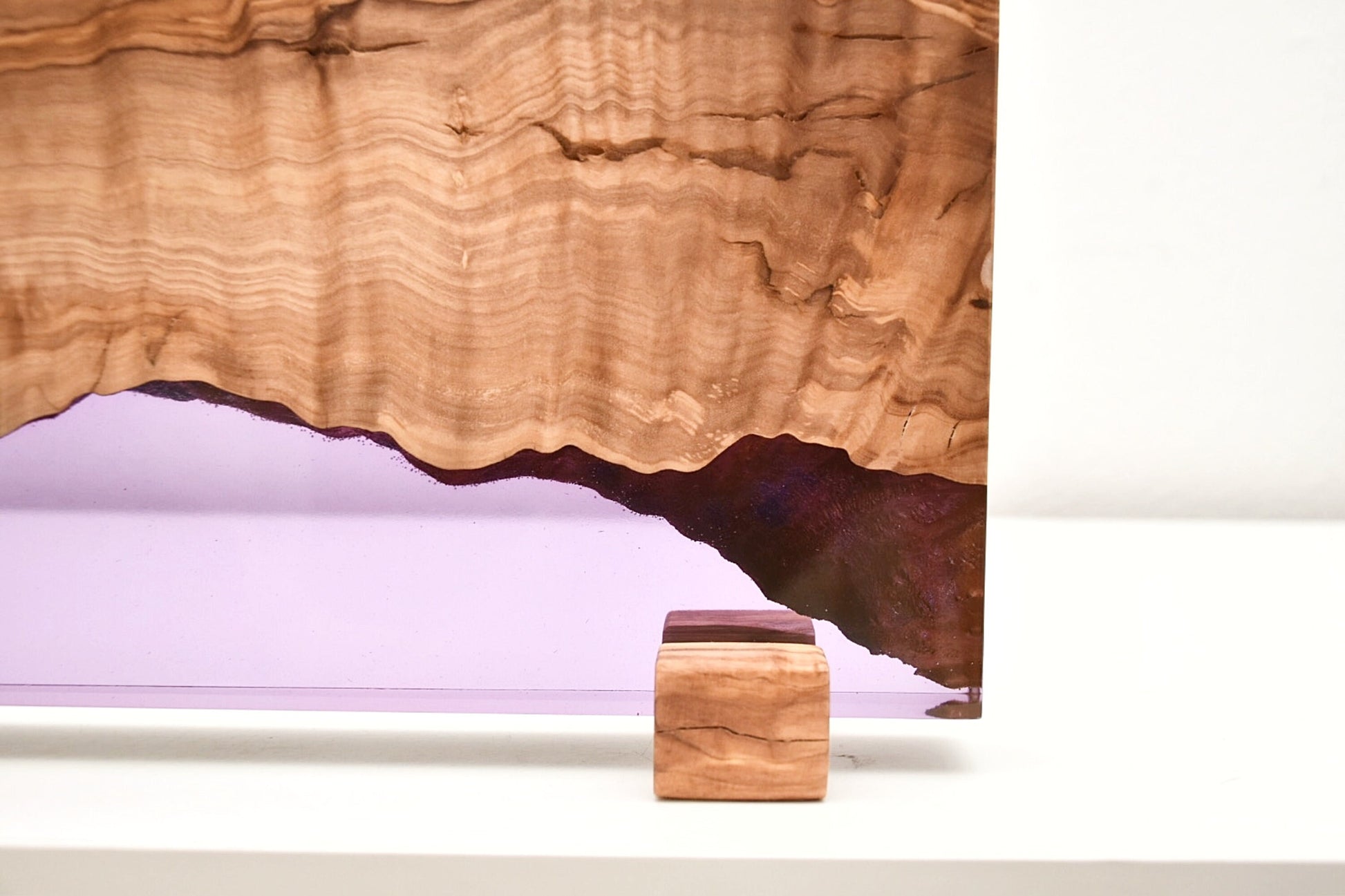 Primer plano de macetero de madera de olivo y resina epoxi lila hecho a mano.
