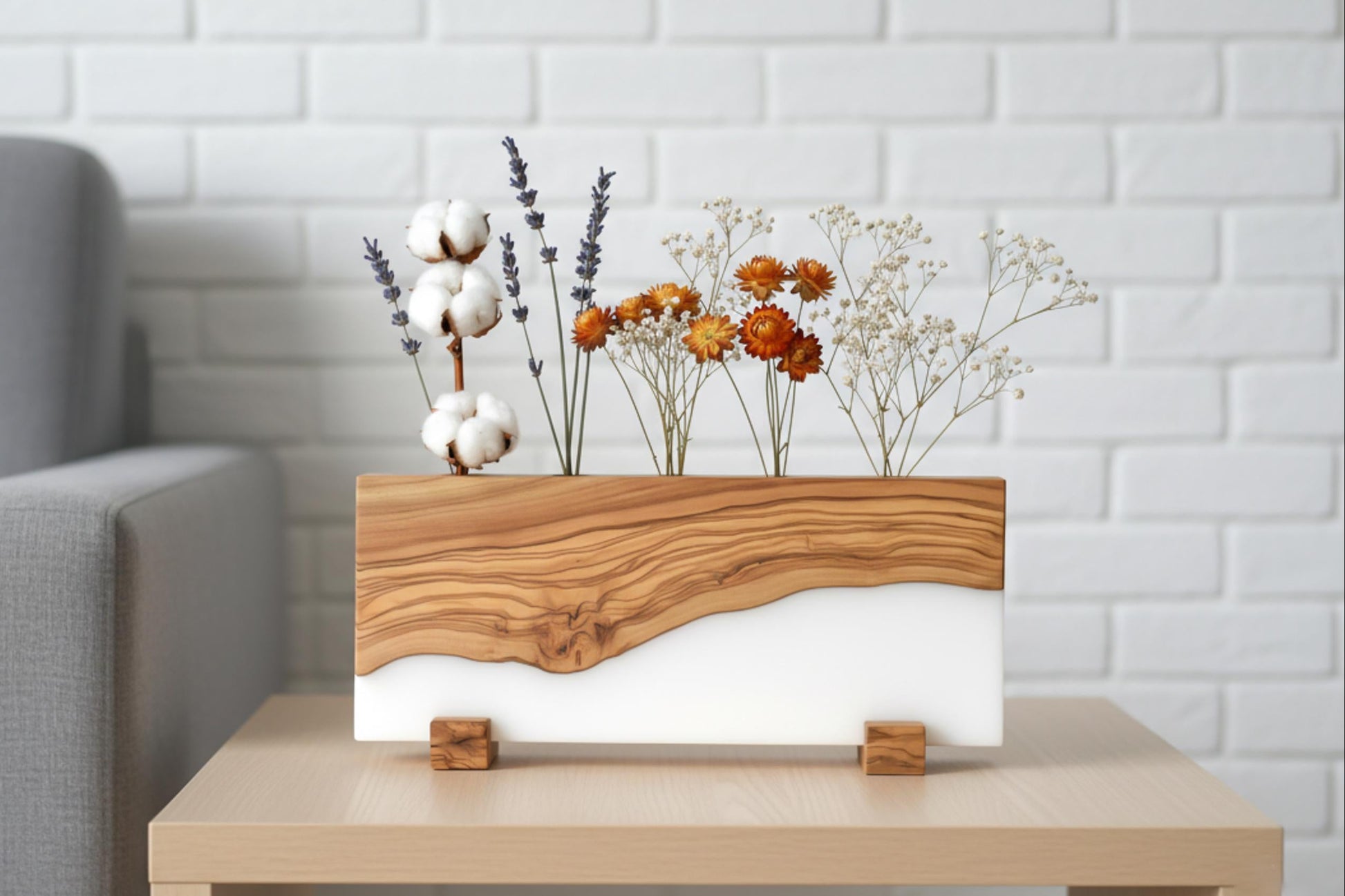Portaplantas artesanal de madera de olivo y resina blanca con flores secas elegantes.