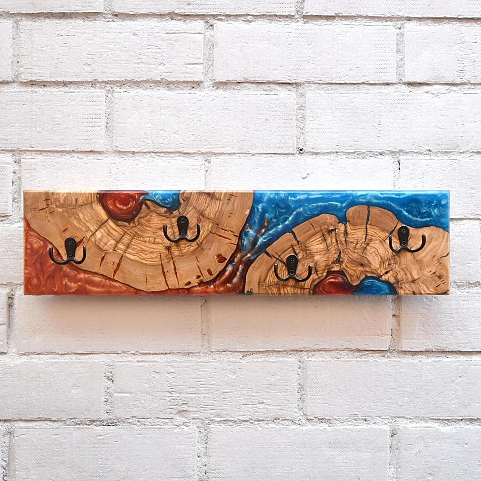 Perchero de madera maciza de olivo con resina epoxy azul y roja, pieza única hecha a mano