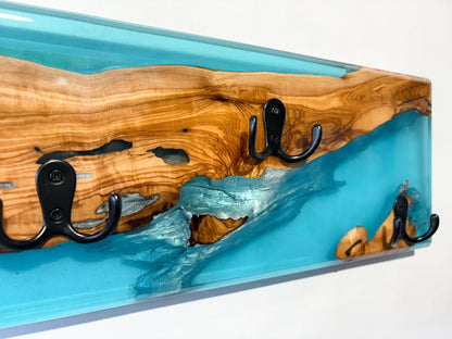 Detalle de madera de olivo con resina epoxy azul en perchero