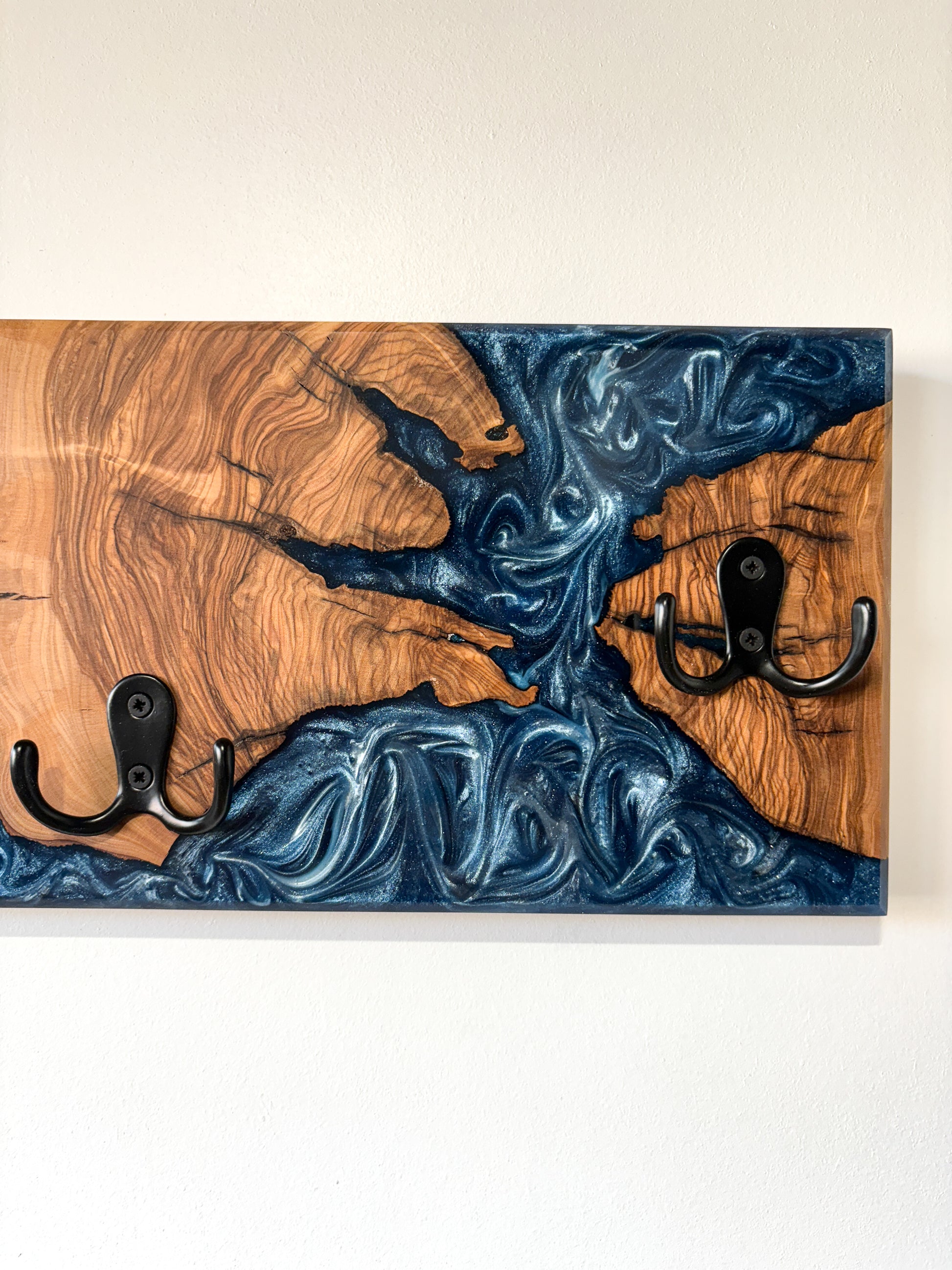 Perchero de olivo con resina epoxy azul, diseño artesanal