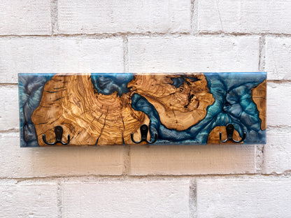 Perchero de madera maciza de olivo con resina epoxy azul, vista frontal