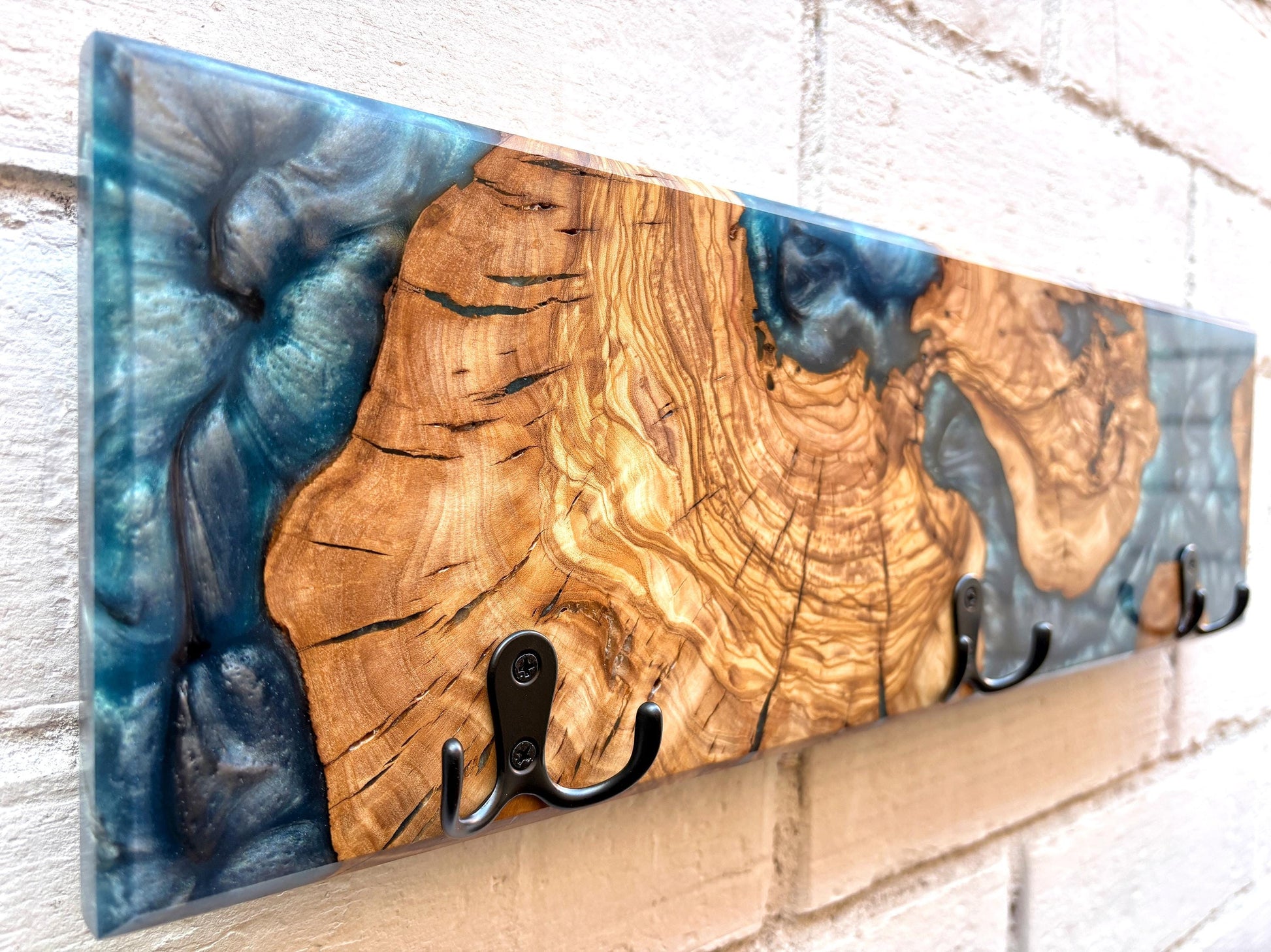 Perchero artesanal de madera de olivo con resina epoxy azul, vista lateral
