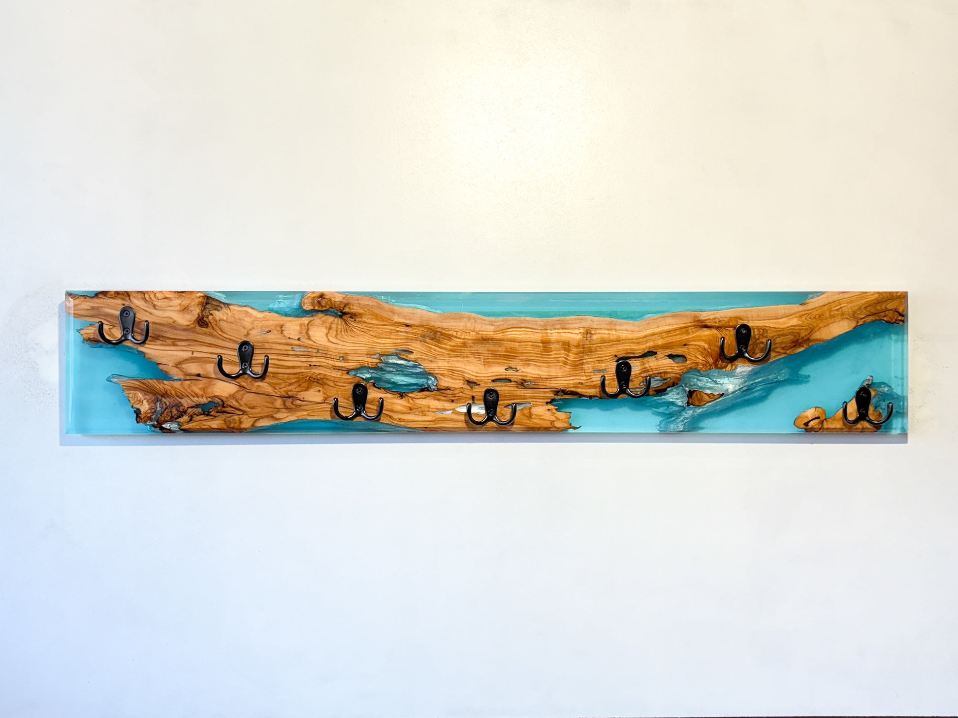 Perchero de madera de olivo con resina epoxy azul, diseño artesanal