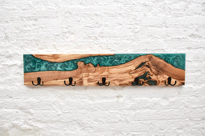 Perchero de pared en madera de olivo con resina epoxy verde, diseño artesanal