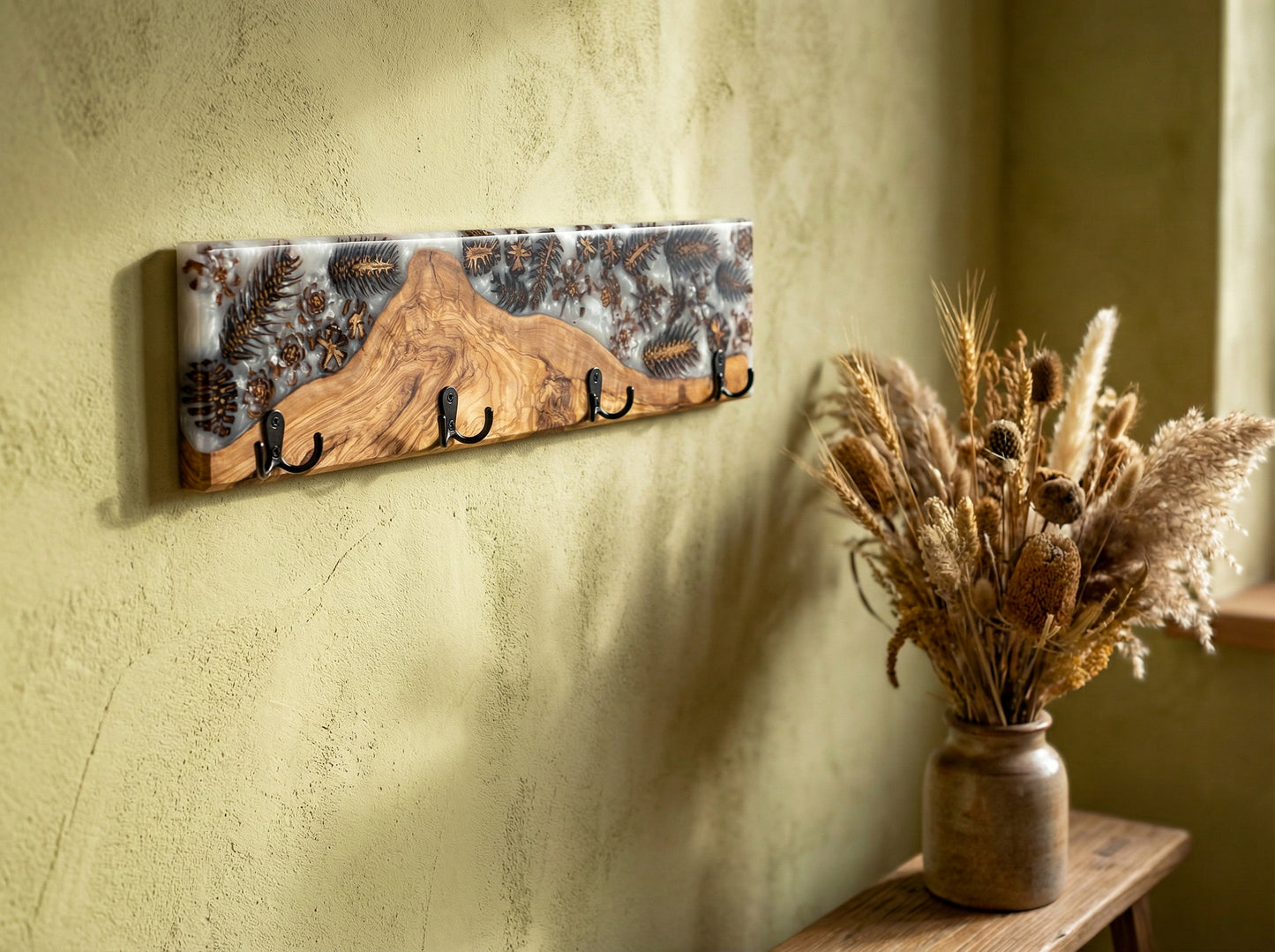 Perchero de pared en madera de olivo con resina epoxy y elementos naturales en ambiente decorativo