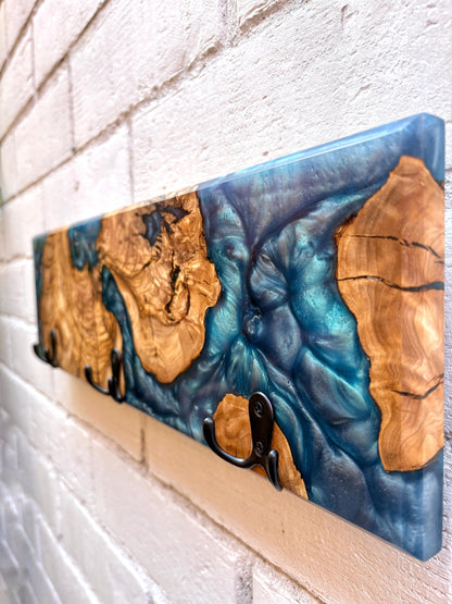 Detalle de perchero en madera de olivo con resina epoxy azul efecto marmolado