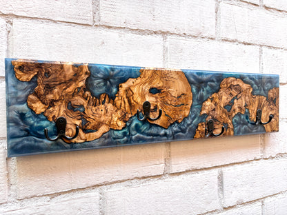 Perchero de madera de olivo con resina epoxy azul, detalle de vetas naturales