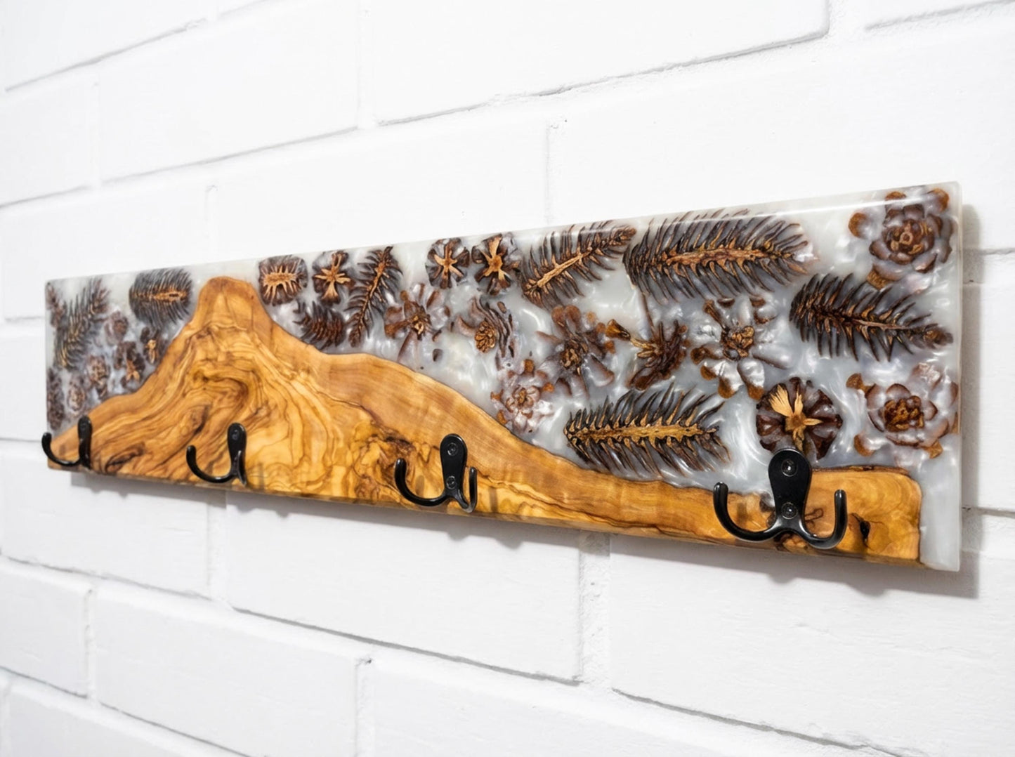 Detalle de perchero en madera de olivo con resina epoxy y piñas incrustadas