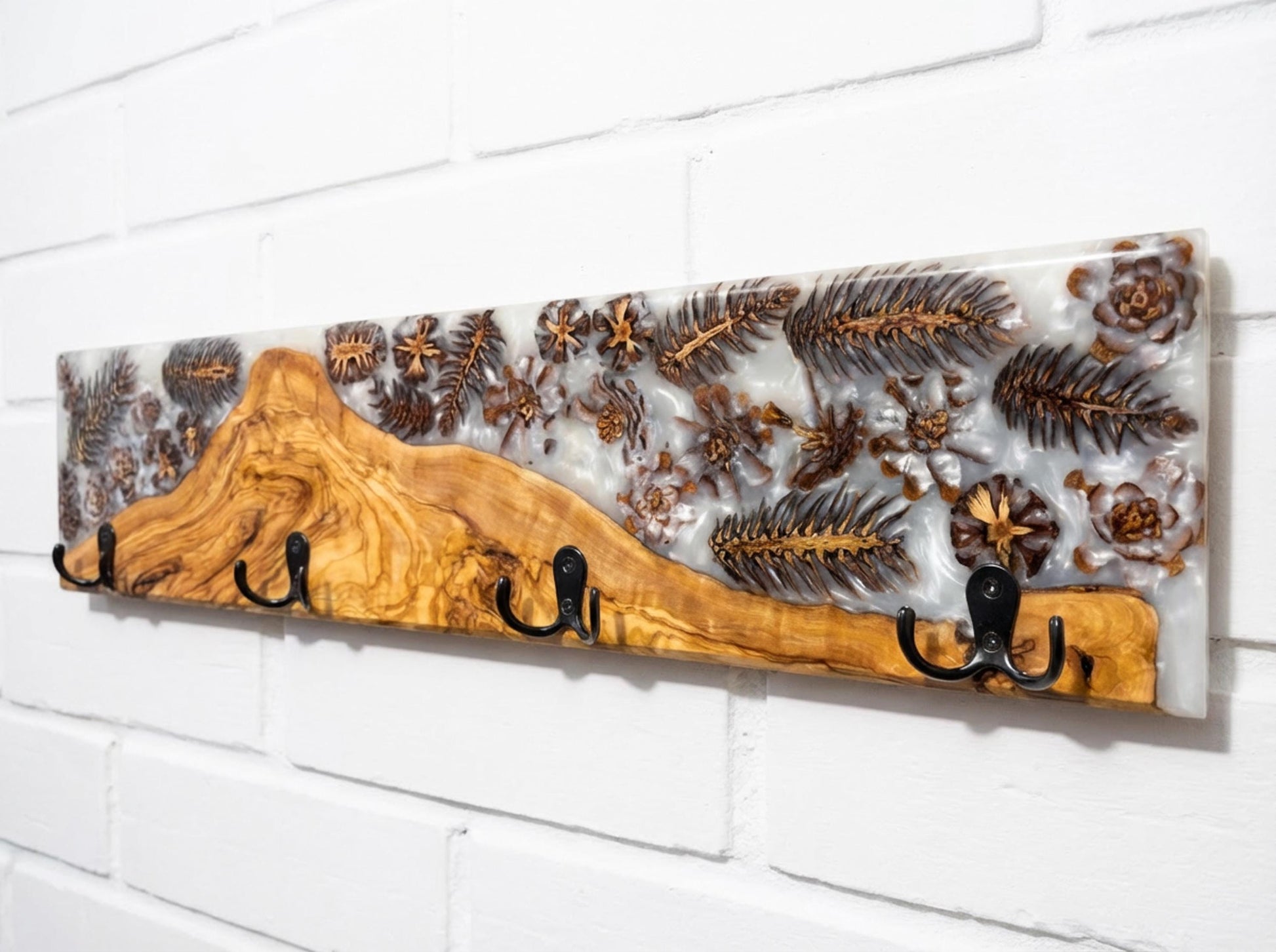 Detalle de perchero en madera de olivo con resina epoxy y piñas incrustadas