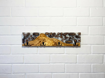 Perchero de pared en madera de olivo con resina epoxy y piñas naturales, diseño artesanal