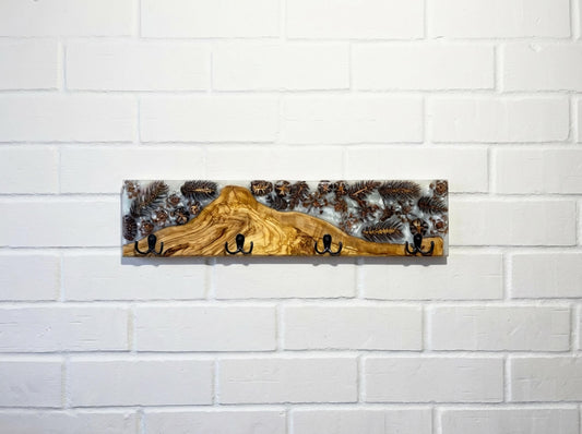 Perchero de pared en madera de olivo con resina epoxy y piñas naturales, diseño artesanal