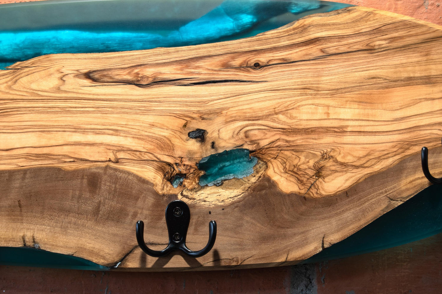 Detalle de perchero skate en madera de olivo con resina epoxy azul