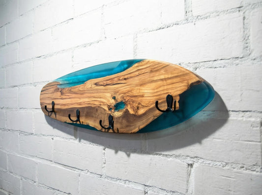Perchero tipo skateboard de madera de olivo con resina epoxy azul, vista lateral