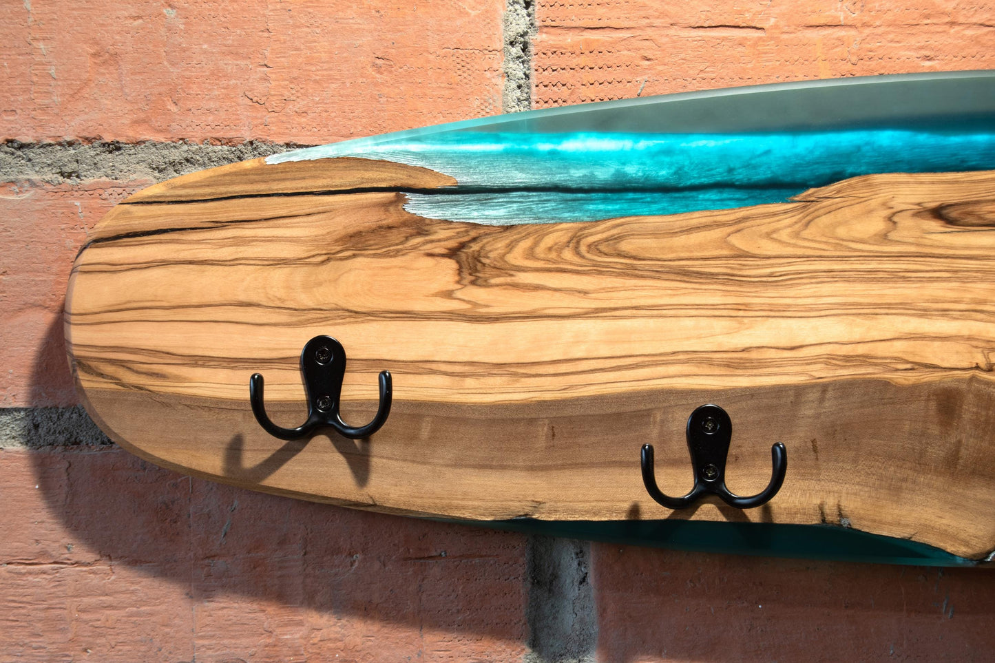 Perchero de diseño skate en madera de olivo con resina epoxy azul turquesa