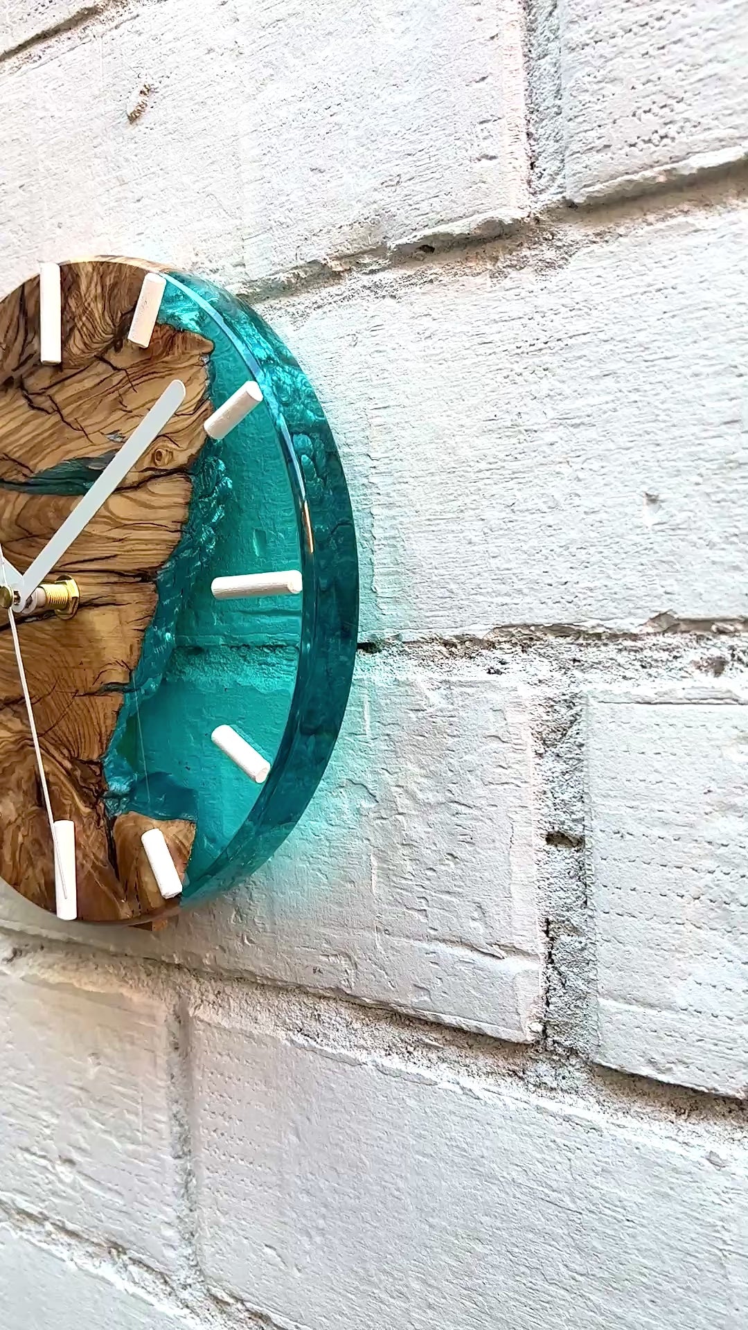 Video de reloj artesanal de madera de olivo con resina epoxy turquesa instalado en pared