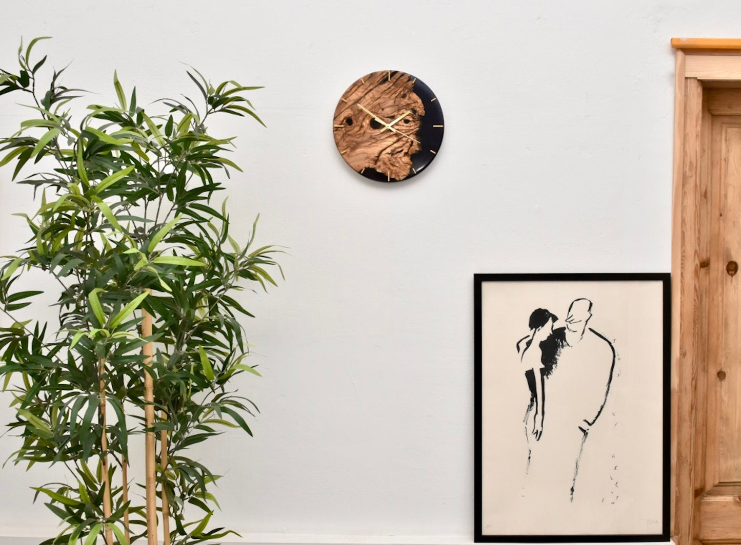 Reloj decorativo colocado en salón junto a plantas y cuadros.
