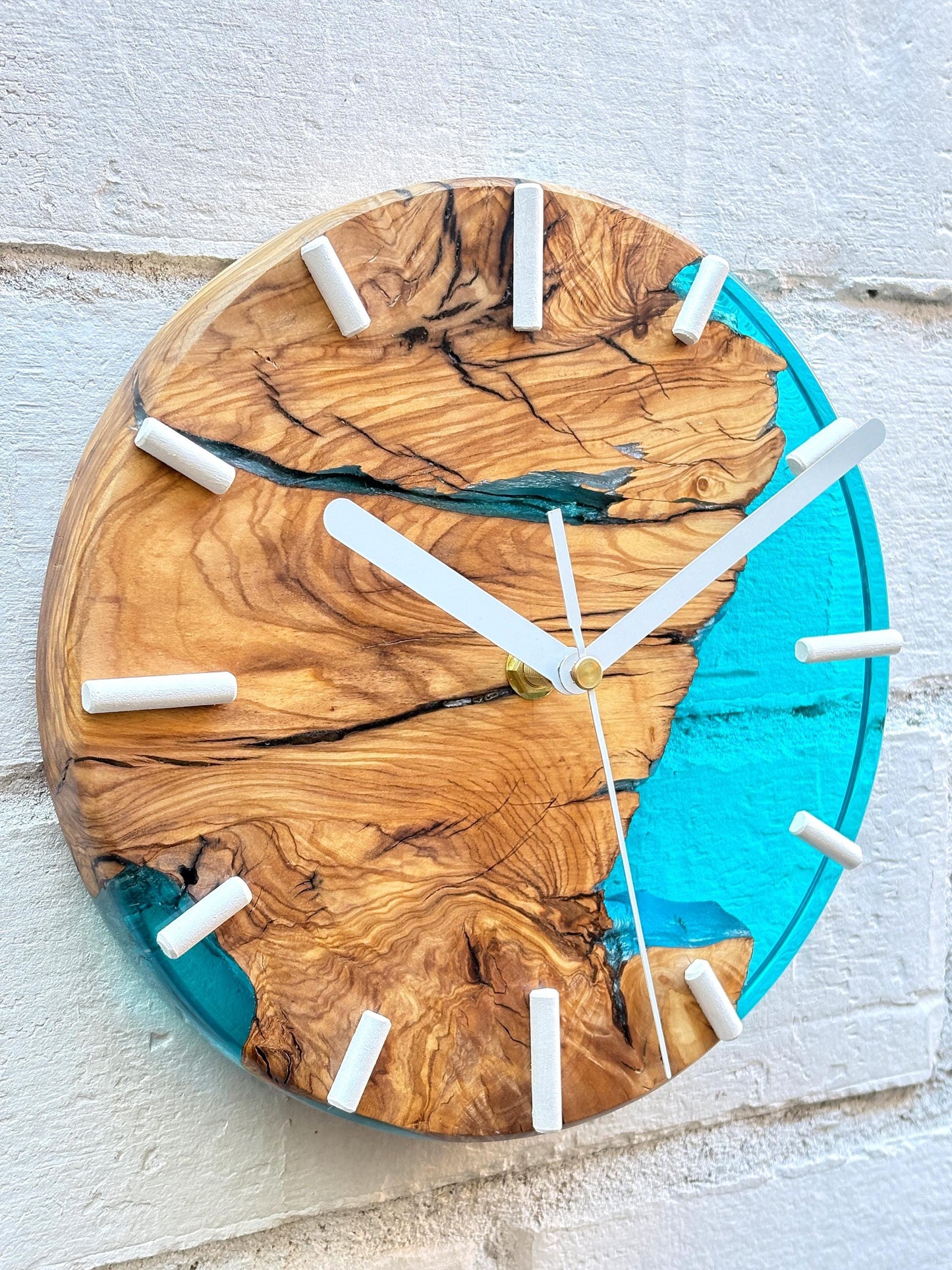 Reloj de pared en madera de olivo con resina epoxy azul, vista cercana