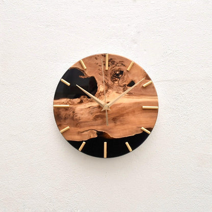 Reloj de madera de olivo sobre pared clara en estilo minimalista.