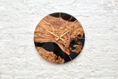 Reloj minimalista de madera natural y resina negra.