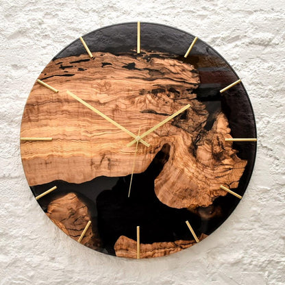 Reloj artesanal de madera de olivo con vetas naturales y resina oscura.