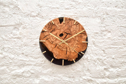 Detalle de vetas de madera de olivo con resina epoxy negra en reloj único 