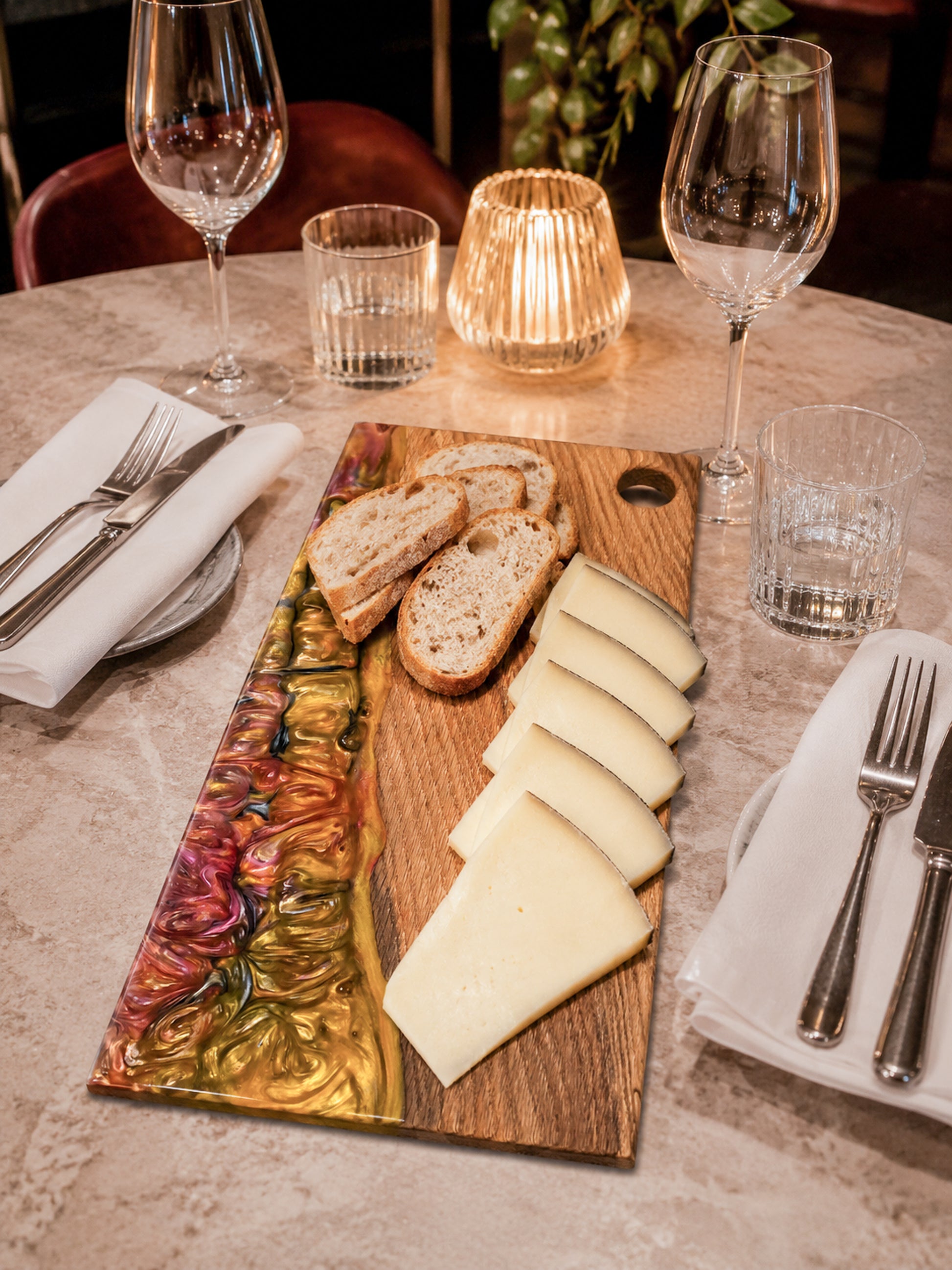 Tabla de quesos de madera de roble y resina epoxi con queso curado y pan artesanal.